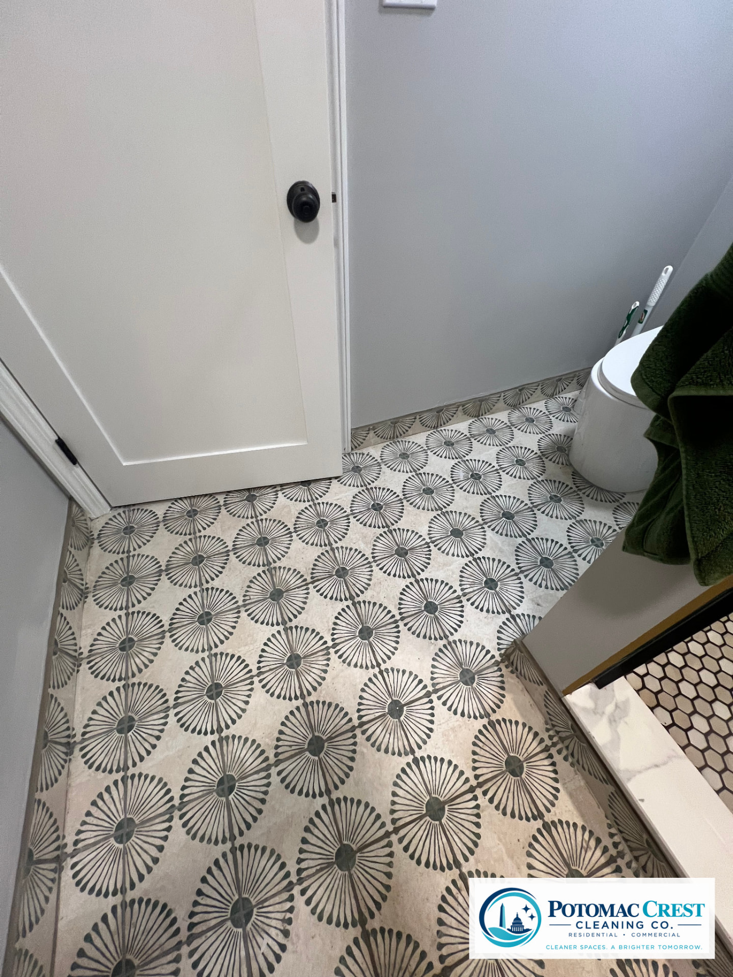 Scrubbed patterned bathroom floor tile and clean white door