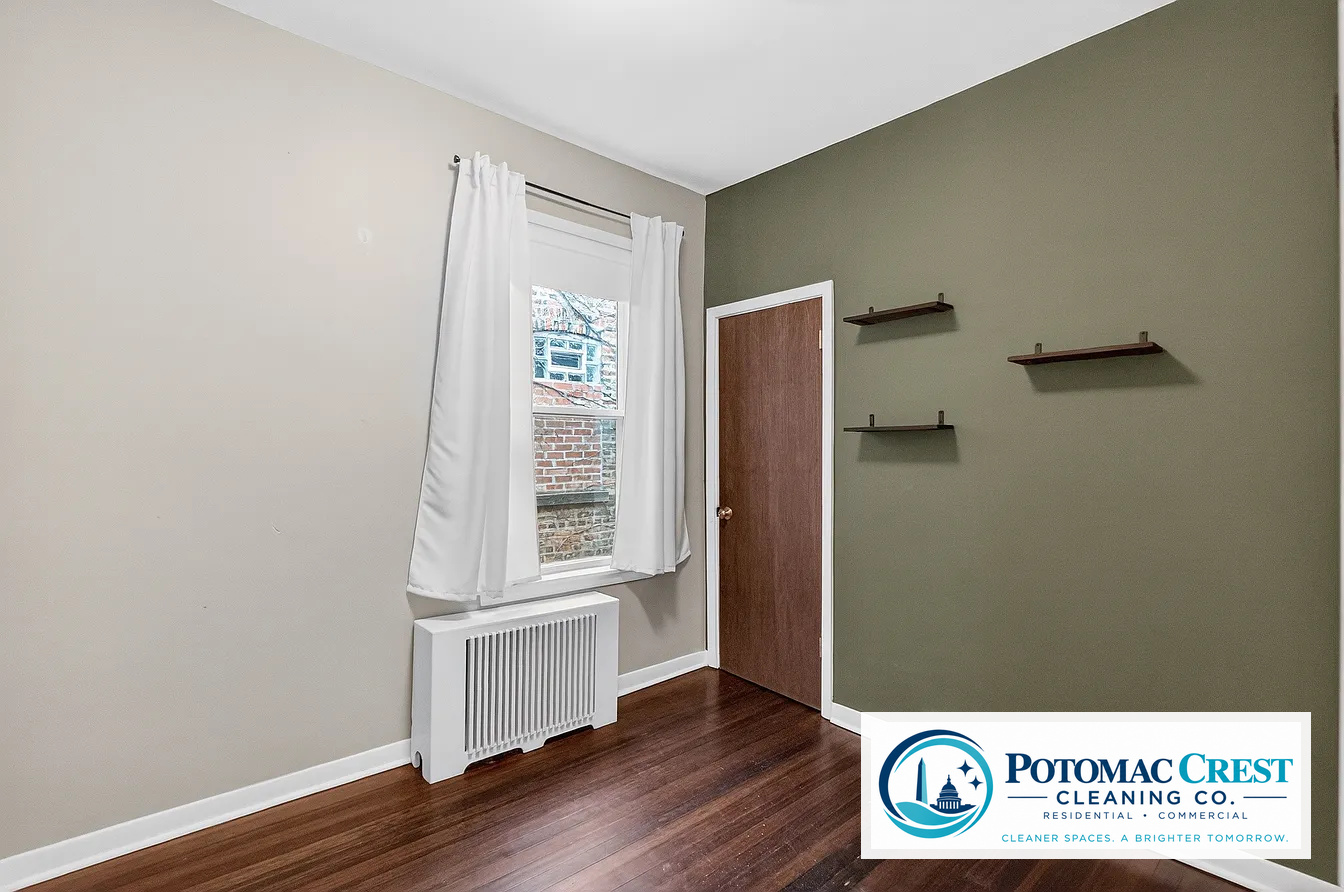 Clean bedroom with polished hardwood floor and white trim